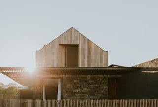 A simple composition in form, but intelligent in detail and execution, the peaked-roof dwelling is a stunning wood- and stone-clad living space.