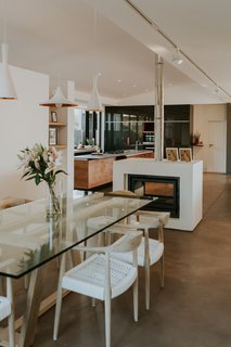 Mainly open in plan, a two-sided fireplace with an open flute quietly divides the spaces on the main floor.
