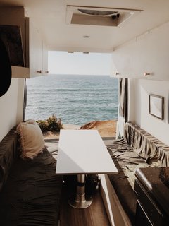 The two benches on each side of the table converted into the couple's bed. When they parked the vehicle, they would open the doors to allow the living space to merge with the outdoors.