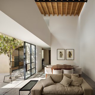 An open walkway between the bedrooms spans across the open living space, revealing the wood rafters above.