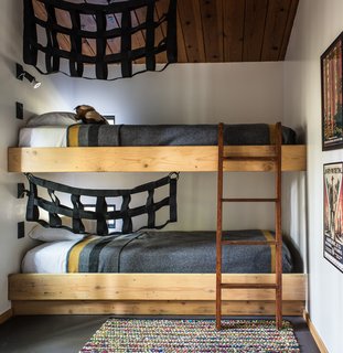 In the second bedroom, built-in bunk beds add an element of playfulness, decorated with black netting.