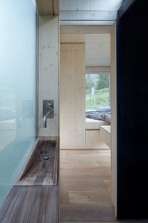 A small walnut washbasin is built into the exterior wall.