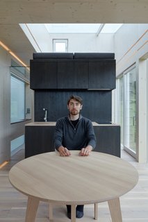 The kitchen space lies on one end of the central black box. Built-in cabinets match the finish of the central massing, appearing as one seamless unit.