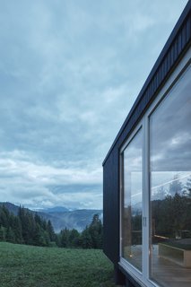 Large sliding glass doors connect the interior spaces to the outdoor elements.