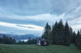 The dwelling is fully immersed in nature, surrounded by scenic vistas and greenery.