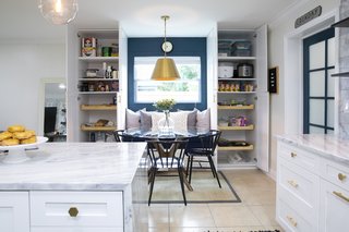 The custom built-ins create the perfect breakfast nook, complete with a built-in bench and pantry storage on both sides. A new window draws additional daylight into the space. 