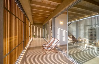 The in-between spaces between the walls of glass and the wooden shutters become exterior living spaces.