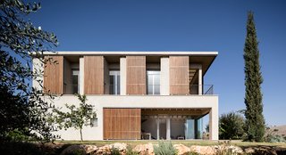 The movable shutters create a playful facade that conceals and reveals interior spaces.