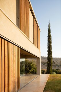 The home is quietly set on the landscape as it reaches out toward both the hills and horizon.