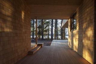 The textured facade playfully displays light and shadows as the sun moves throughout the day and seasons. The framed breezeway reaches outward to the fjord.