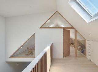 Wood framed glazing follows the slope of the gable above, referencing the original roof shape of the home.