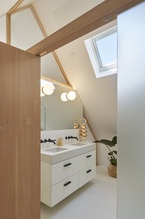 In the master bath, an IKEA vanity with matte black wall faucets from the Jason Wu for Brizio collection continue the simple, contemporary feel of the home. Skylights allow light to enter even the most private of spaces.