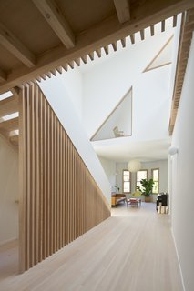 Located at the center of the home, the new two-level atrium connects the existing living areas to the attic spaces above.
