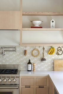 Open wooden shelving serve as an idyllic spot to display special kitchen gadgets and trinkets.