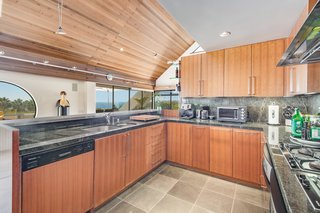 Emerald stone countertops and other rich materials create an ideal chef's kitchen with views to the ocean.