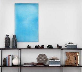 Open-shelving credenzas were custom-designed to align with the window mullions. This sits under a Tom Burrows, Derambila piece from Foster/White Gallery in Seattle. 