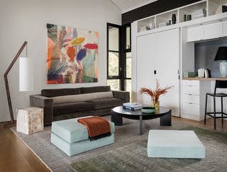 The open loft space above is filled with simple furnishings, colorful artwork, and rich textiles.