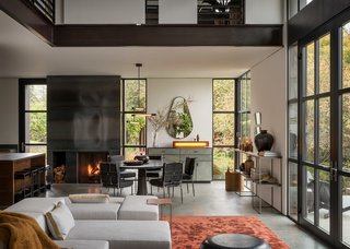 A steel fireplace lies between the dining space and open kitchen.