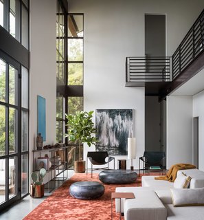 The double-height, glazed living spaces allow for plentiful natural light and unobstructed views to the surrounding landscape.