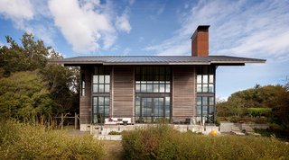 Designed by Olson Kundig with interiors by Geremia Design, False Bay Residence takes cues from the surrounding agricultural buildings on the site. A steeply pitched roof, open interior, loft space, and overall height resonate with the vernacular of the area.