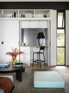 Full-height case work includes a built-in desk, which can be concealed behind pocket hinge doors when not in use.