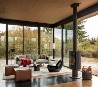 The cozy sitting area is an ideal writer's retreat. Full-height glazing provides unobstructed views to the outdoors. A rotatable fireplace allows the warmth to be enjoyed from either the inside or outside.
