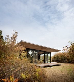With floor-to-ceiling windows and custom shutter-deck enclosure, the 500-square-foot cabin feels totally connected to the natural landscape.