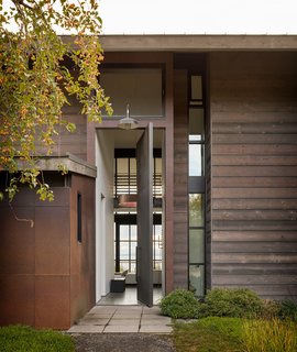 Olson Kundig's natural and warm architectural palette combines metal, wood, and concrete, set against the blues and greens of the lush surroundings and bay.