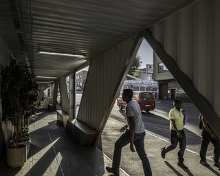 On the ground floor, diagonal cuts connect the public sidewalk to a covered portico.