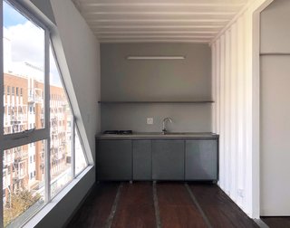 The shipping container walls have been painted white on the interior, creating bright living spaces.