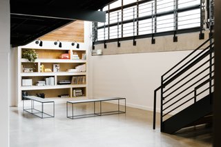 Operable glass garage doors surround the two-story atrium, connecting the upper and lower floors as one open, collaborative workspace.