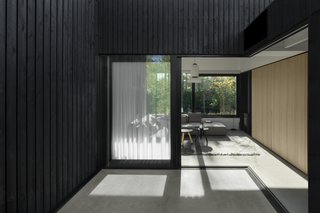 Large sliding glass doors open the living room up to the outdoors, blurring the boundary between inside and outside. 