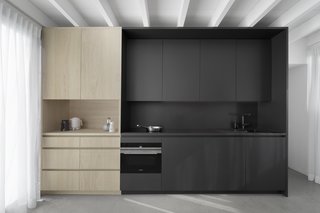 Natural and black painted oak cabinets provide plentiful storage in the galley kitchen. 