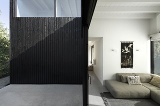 The darkly stained exterior contrasts with the white, light-filled interiors. 