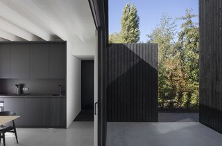 Large sliding glass doors extend to the kitchen and dining area, creating outdoor cooking space when fully open. 