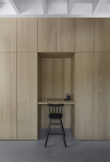A recess in the floor-to-ceiling cabinetry provides a small working space. 