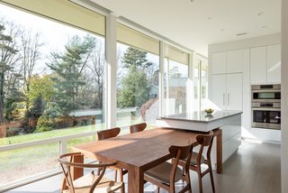 The uniquely designed kitchen island extends above the dining table to provide additional space for dining and cook prep. When not in use, the dining table can be pulled away, providing a freestanding island.