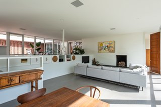 The open floor plan blends cooking, dining, and living spaces. The brick fireplace remains the heart of the home. Contemporary artworks by the homeowner's father, Richard Hagerty, an American surrealist, decorate the home's living spaces.