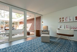 A charming nursery looks onto the inviting courtyard. Custom "midcentury vascular anatomy" artwork by owner Andre Uflacker, a radiologist and painter, adorns the space.