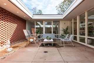 The interior courtyard is one of the best rooms in the house, embracing daylight and shadows. Originally designed to hold a tree at the center, the courtyard now includes a fire pit.