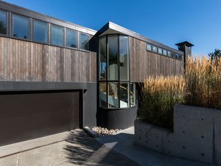 Clad in natural materials, the residence is truly at home in the Pacific Northwest. Tall glazing provides a glimpse inside, with peeks of the elegant, spiral stair.