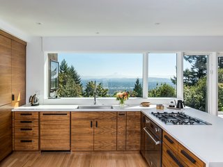 A large picture window provides endless views of the Cascade Mountains from this contemporary, open kitchen. 