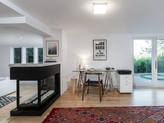 On the lower level, a three-sided fireplace doubles as a room divider that separates the media room from an office space.