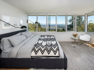 Picturesque views surround this master bedroom. From the relaxation and comfort of the indoors, you can enjoy all the surrounding landscape has to offer. 