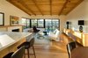 Modern home with Living Room, Chair, Sofa, End Tables, Coffee Tables, Console Tables, Media Cabinet, Table, Stools, Storage, Shelves, Lamps, Ceiling Lighting, Track Lighting, Table Lighting, Accent Lighting, Light Hardwood Floor, Rug Floor, Standard Layout Fireplace, and Gas Burning Fireplace. Living Room at sunrise frames backyard from Kitchen and Dining (in foreground) Photo 19 of Ridgemont Residence