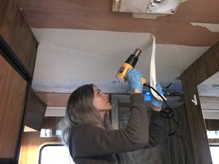 A Portland Couple Renovate a 1982 RV, Turning It Into Their New Home - Photo 4 of 12 - Kamarul removing wallpaper from the ceiling.