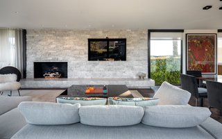 An open-plan living/dining/kitchen area takes full advantage of the ample light from multiple floor-to-ceiling windows.