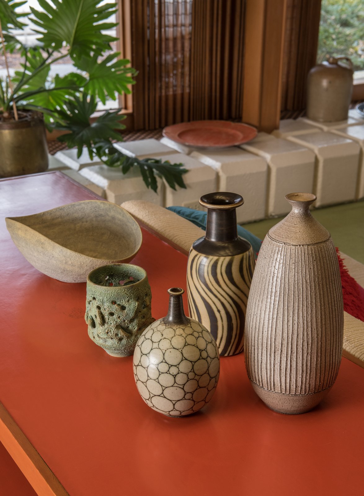 “Each element contributes its own part to the entire whole,” says Quinn. “Going through structure, integrating iconic pieces, it was about the feel.” A mix of McIntosh and Natzler ceramics is displayed in the living room.