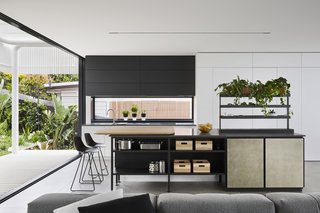 In the bright and airy kitchen, top-of-the-line appliances include a Miele integrated refrigerator, a Liebherr freezer unit, and a concealed Qasair Condari Westmore rangehood. The Salinas System Kitchen island was designed by Patricia Urquiola for Boffi. 