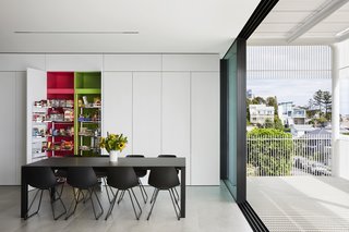 Sleek cabinetry extends from the kitchen to the dining room for extra storage.